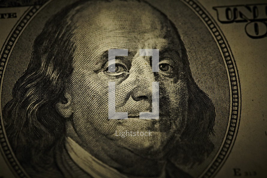 Close up of Benjamin Franklin's face on a one hundred dollar bill
