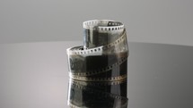 35mm film negative rotating on a reflective surface. Studio shot
