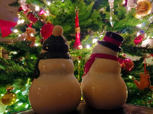 Ceramic snowmen looking at Christmas tree