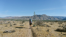 a woman hiking on a desert trail 