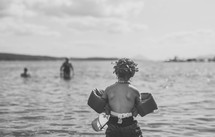 a child in a floatie playing at a lake 