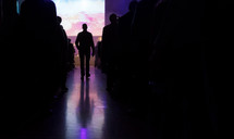 a man walking down an aisle during a worship service 