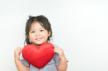toddler girl holding a red heart 