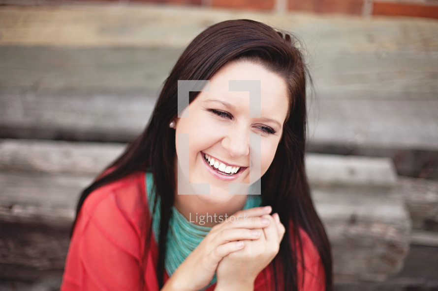 smiling woman clasping her hands together