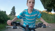 POV of a young boy enjoying a bicycle ride on the rural countryside.