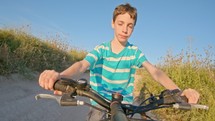 POV of a young boy enjoying riding his bicycle on the rural countryside.