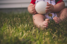 infant boy holding a baseball 