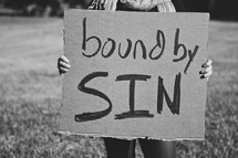 Girl holding "Bound by Sin" sign
