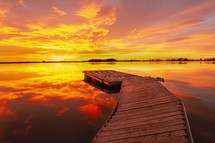 A brilliant colorful sunrise as the fishing dock awaits the sun