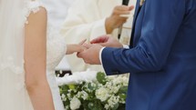 Bride and groom wear their wedding ring