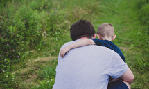 father and son hugging outdoors 