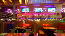 A young man sitting alone in a booth in a cafe decorated for Christmas surrounded by lights, color, televisions, music and activity while sitting alone in solitude with his smart phone. How often do we take relationships for granted in this day and age of moving pictures, sound, multimedia and technology. It is not technology that satisfies the soul but a relationship with Jesus Christ. How many people today are surrounded by computers, televisions, movies, smart phones and technology but it does not satisfy or fulfill the needs for a savior in the form of Jesus Christ. The holidays can be a lonely time for many who are looking for something to fulfill their lives but it can only be found through Christ. 
This holiday season, tell others about Jesus, invite them to church, show them friendship and make them feel loved and appreciated for this is what the Christmas season is all about, a man named Jesus who longs to fill our needs and bring us back to a relationship with HIm. 