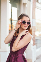 woman in a formal maroon dress and sunglasses 