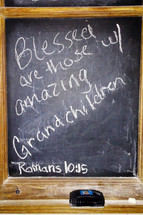 A chalkboard complete with chialk and eraser with the words "Blessed are those with amazing Grand Children" and the verse Romans 10:15 referencing the verse "And how can anyone preach unless they are sent? As it is written: “How beautiful are the feet of those who bring good news!”" Children who are raised in a Christian home to grow up and share the gospel with others is the hope of every Christian parent. They are blessed when their children grow up and fulfill the calling of God in their lives including going out and spreading the gospel to all nations. 