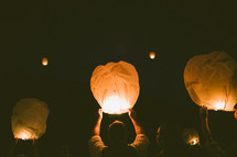 realeasing paper lanterns into the night sky