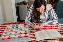 a woman stuffing Bible verses into an Advent calendar 