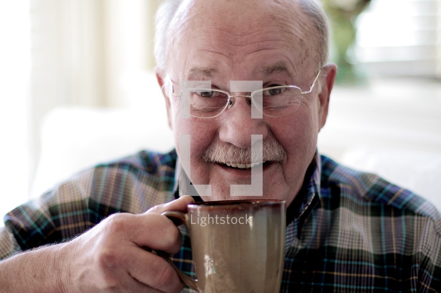 Elderly man drinking cup of coffee
