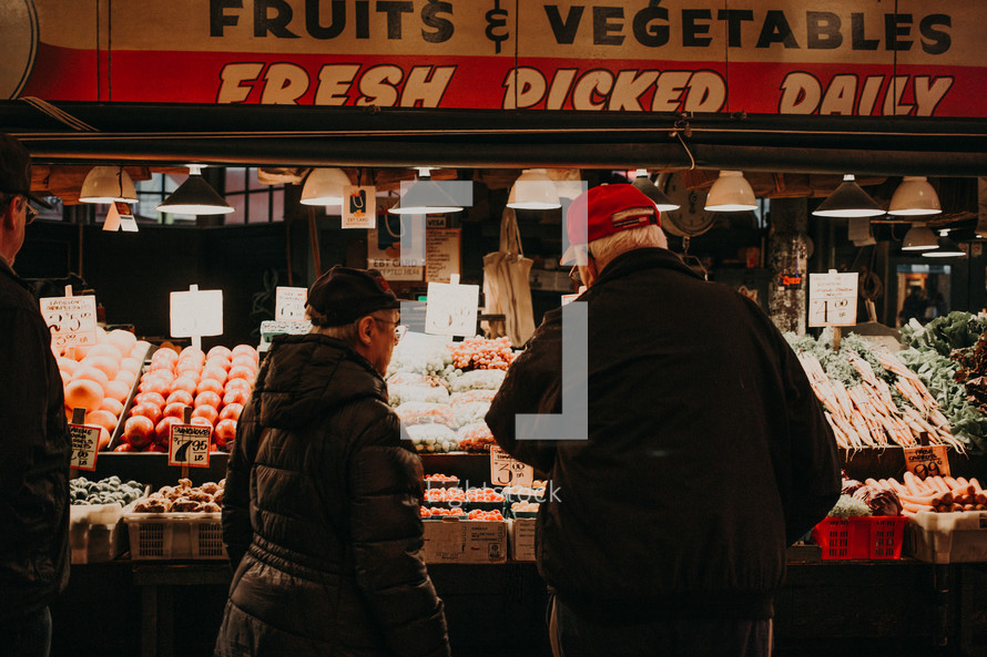 people shopping for produce at a market 