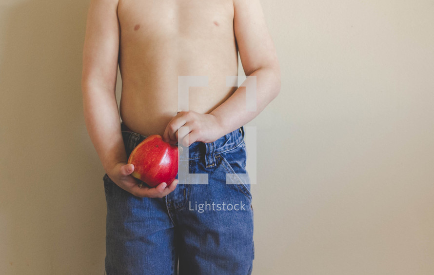 torso of a boy child holding a red apple 