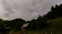 Clouds moving fast in evening sky over holiday cottage in forest mountains nature Time-lapse
