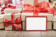 brown gift boxes with red ribbons and a blank gift tag
