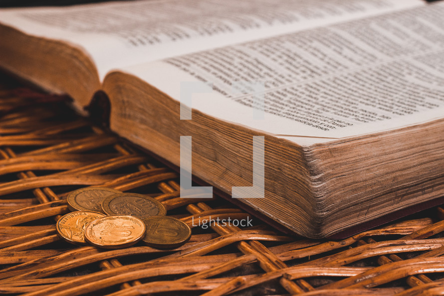 open Bible and coins in a basket 