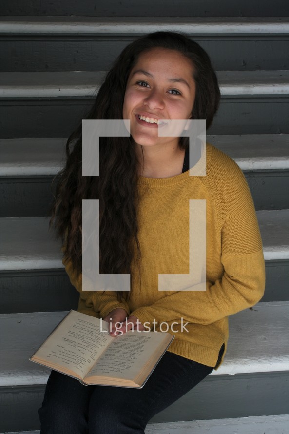 smiling young woman reading a book 