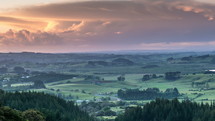 Sunrise over green rural countryside in summer morning in New Zealand nature Time-lapse
