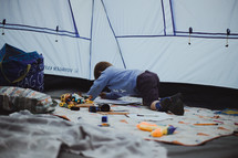 boy playing with toys in a tent 