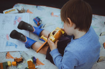 a boy playing with toys in a tent 