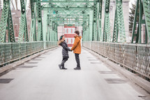a couple holding hands on a bridge 