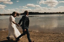 bride and groom walking on a beach 