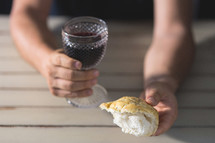 man holding communion bread and wine 