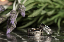 Two diamond wedding bands near some lavender.
