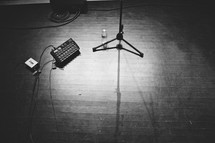 empty stage with guitar pedals and microphone stand