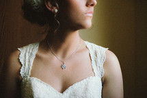 View of a bride's necklace and dress; neck down