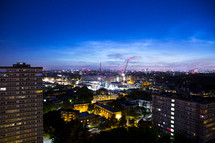 city lights at night and construction cranes 