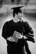 college graduate holding a Bible