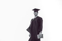 Smiling graduate holding a Bible.