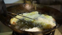 Frying zeppole in a pan with oil at a city festival in Calabria