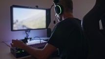 Man playing a flight simulator on the computer, wearing a headset