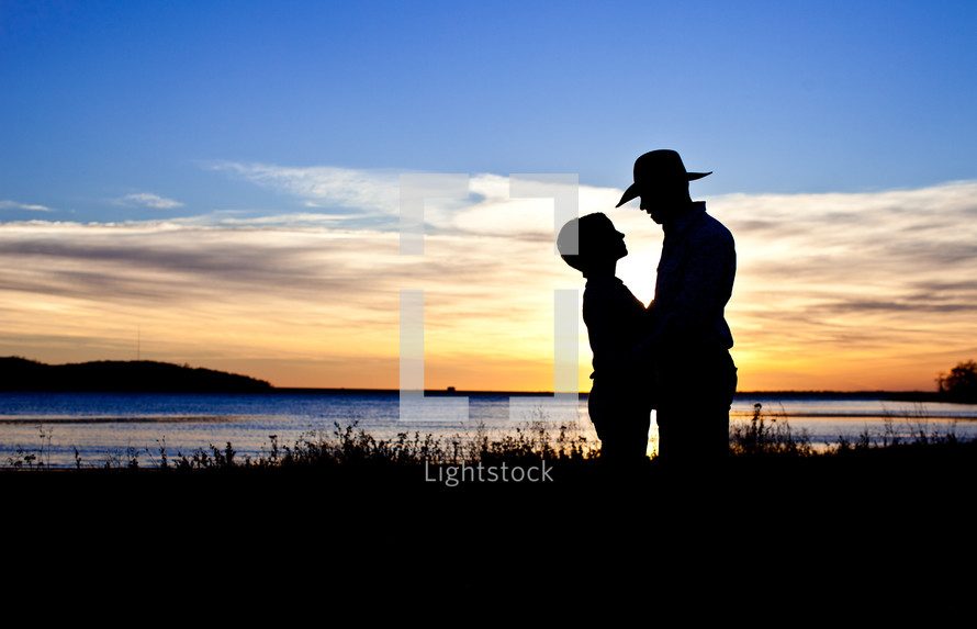 silhouette of a woman and man ln a cowboy hat