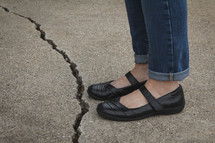 woman standing beside a crack 