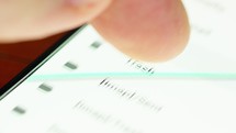 Close up of hand browsing through mail folders a smartphone screen