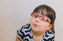 face of a girl child in reading glasses 