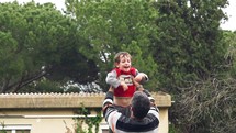 Slow motion of dad throwing his adorable son in the air