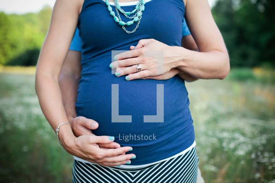 expecting couple holding a pregnant belly