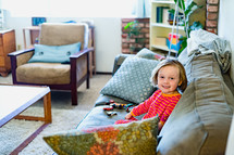 a child sitting on a couch playing with toy cars 