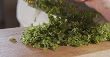 Slow motion of chef knife slicing celery leaves