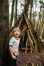 child with a teepee of sticks 